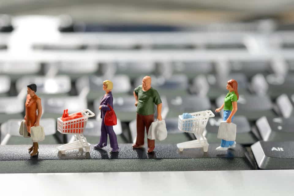 Miniature shoppers with shopping cart